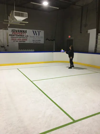 A player at the far end of the pickleball court